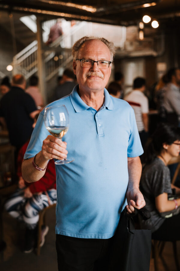 Man holding a glass of wine at Canadians Connected: Edmonton