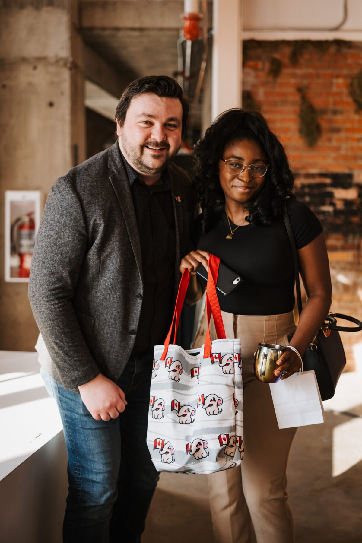 Chad Ohman and an attendee holding a mastodon bag smiling