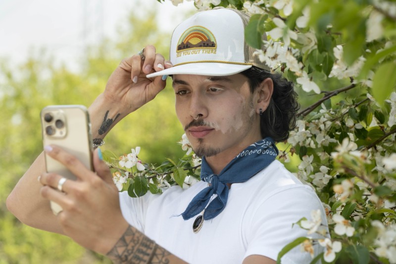 Man taking a selfie surrounded by flowers